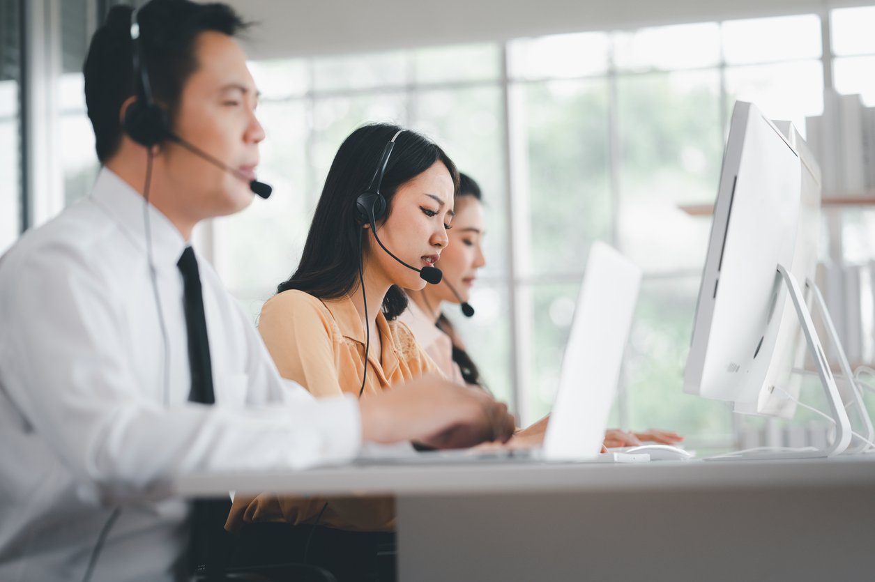 Contact center agents speaking with customers through headsets